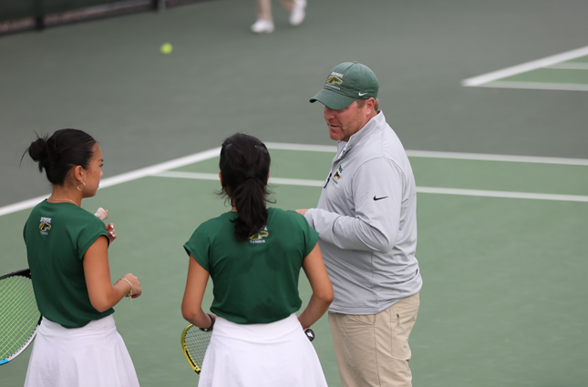 Konika Dhull ’25 and Grace Truong ’25 talk to head women's tennis coach Curt Speerschneider.