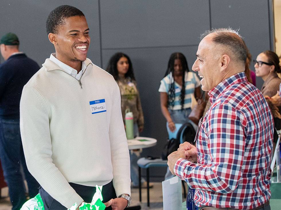 A student smiles while speaking to an alum in the Billie Tisch Center for Integrated Sciences