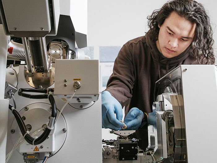 A student conducts research using a scanning electron microscope in a campus laboratory, demonstrating hands-on learning and scientific exploration at Skidmore College.