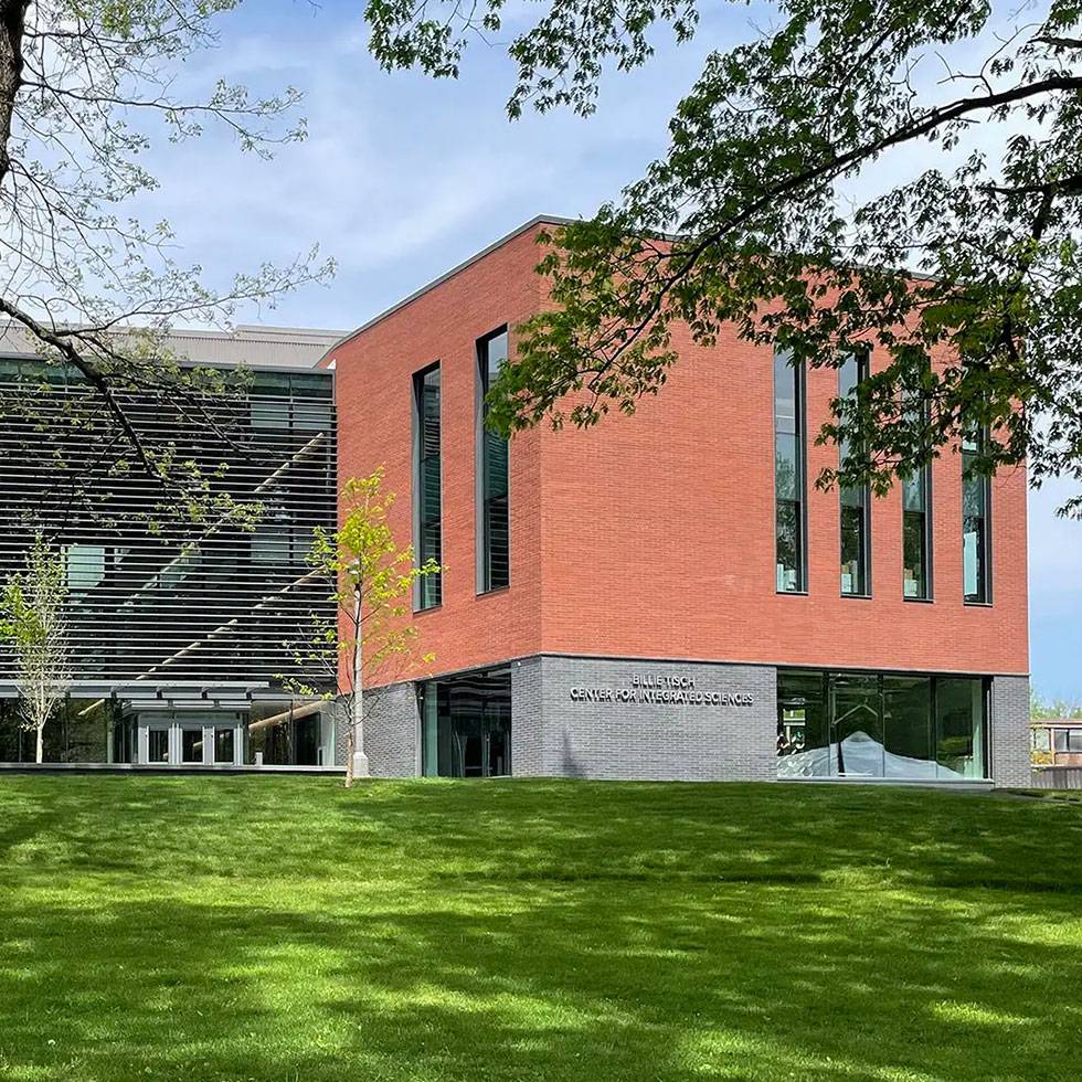 Summer time exterior image of the Billie Tisch Center for Integrated Sciences with beautiful green lawn and blue sky.