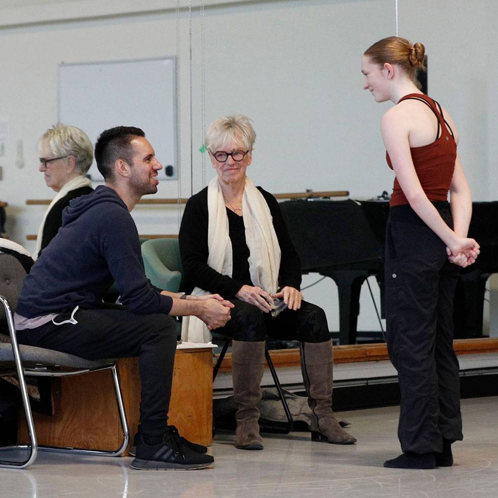 A student stands talking to guests artists in Skidmore's Dance performance space