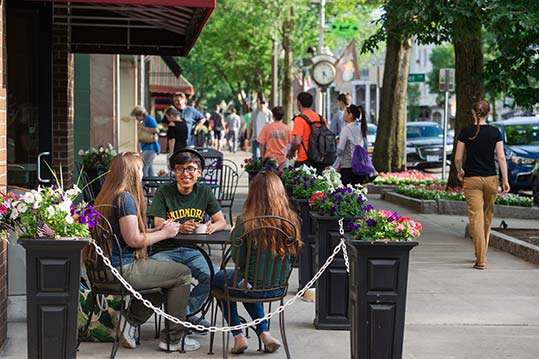 Students sitting outside at a downtown Saratoga Springs cafe