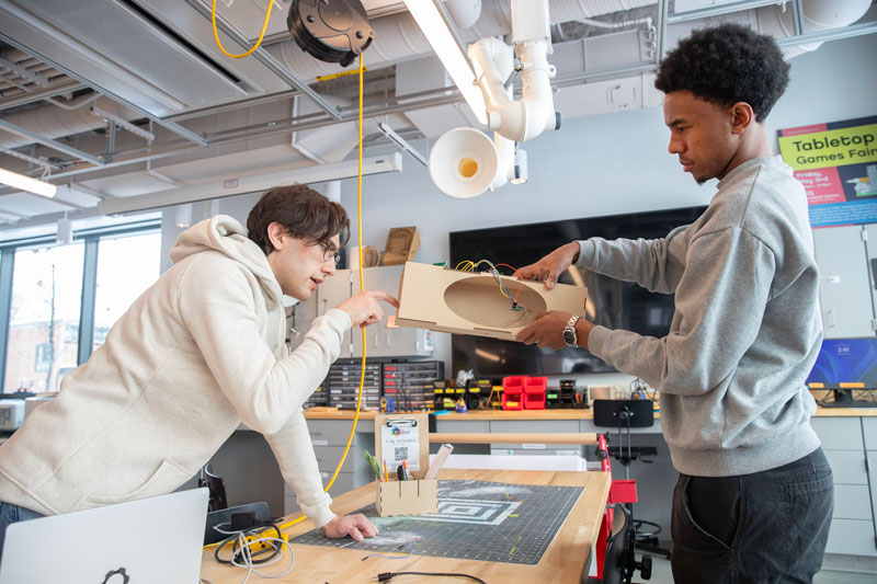 Two students work together on a prototype in a creator lab