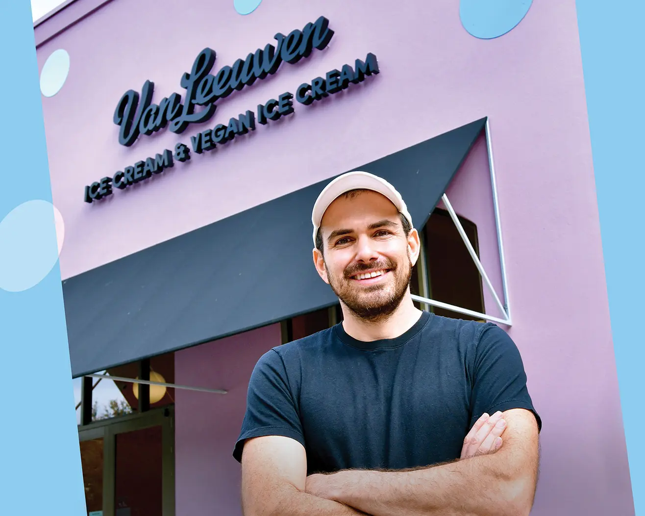Ben Van Leeuwen stands with arms crossed in front of a pastel pink Van Leeuwen Ice Cream shop with a sign that reads “Ice Cream & Vegan Ice Cream.”