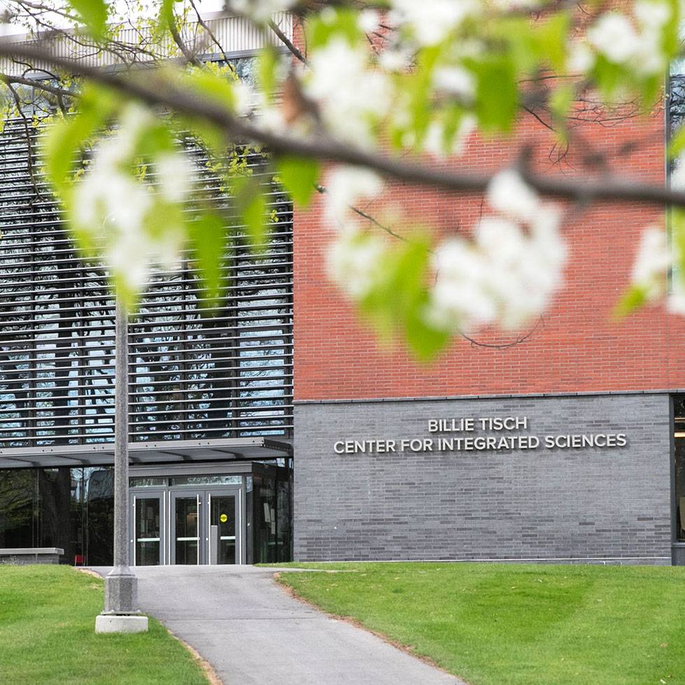 Exterior of Billie Tisch Center for Integrated Sciences with flowers hanging above in foreground.