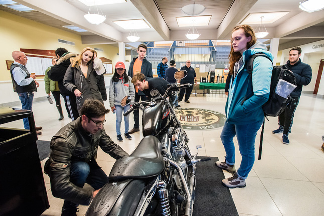 Student inspect a Harley Davidson motorcycle