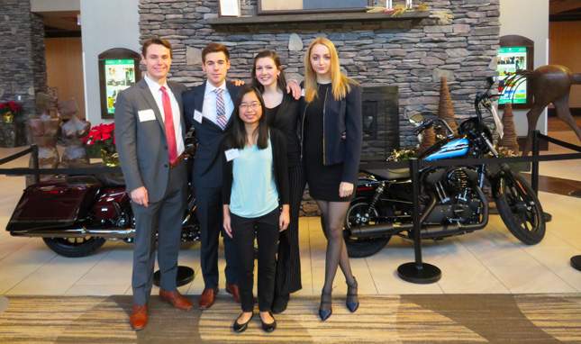 Members of an MB107 team pose in front of Harley-Davidson motorcycles in the lobby of the Embassy Suites hotel in Saratoga Springs following their executive presentation. Clockwise from left: Jack Leitner, ’19 (coach), Spencer Bernard, ’22, Alix DuBouloz, ’22, Antonia Meade, ’22, Grace Smith, ’22.