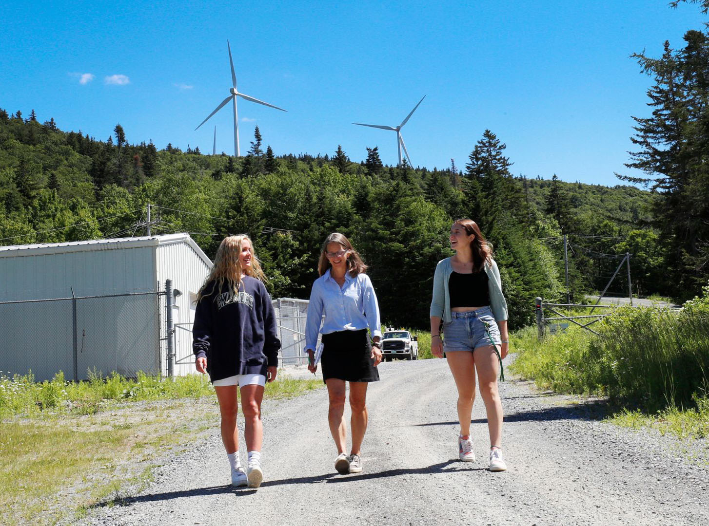 Karen Kellogg, professor of environmental studies and sciences, center, talks with Skidmore College students Paige Karl ’24, left, and Chloe Faehndrich ’23 at a wind farm in Vermont in summer 2021.
