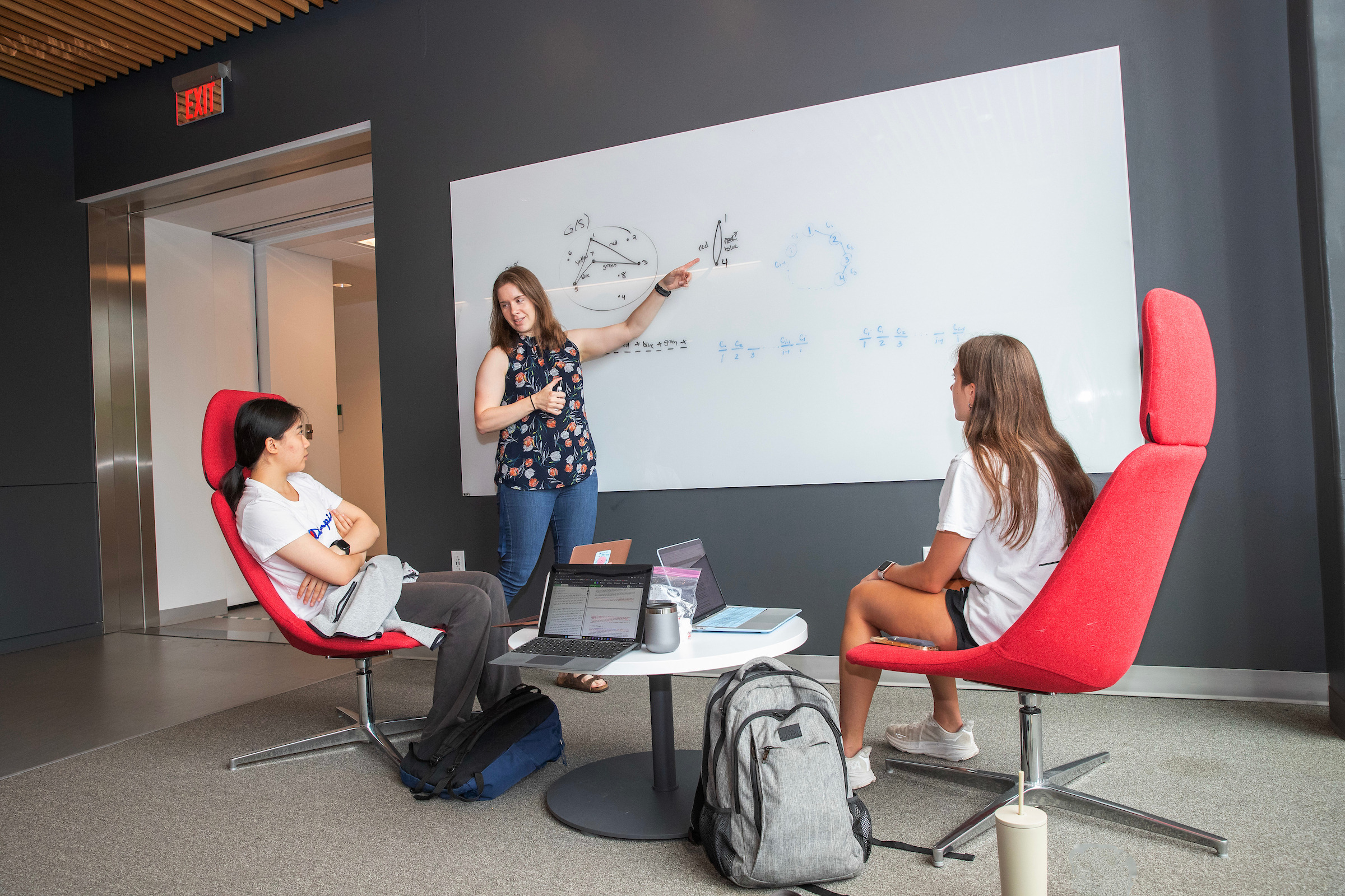 Professor Kirsten Hogenson works with math majors Rachel Xia ’26 and Riley Vavolizza ’26 during their summer research on Rainbow Static Mastermind.