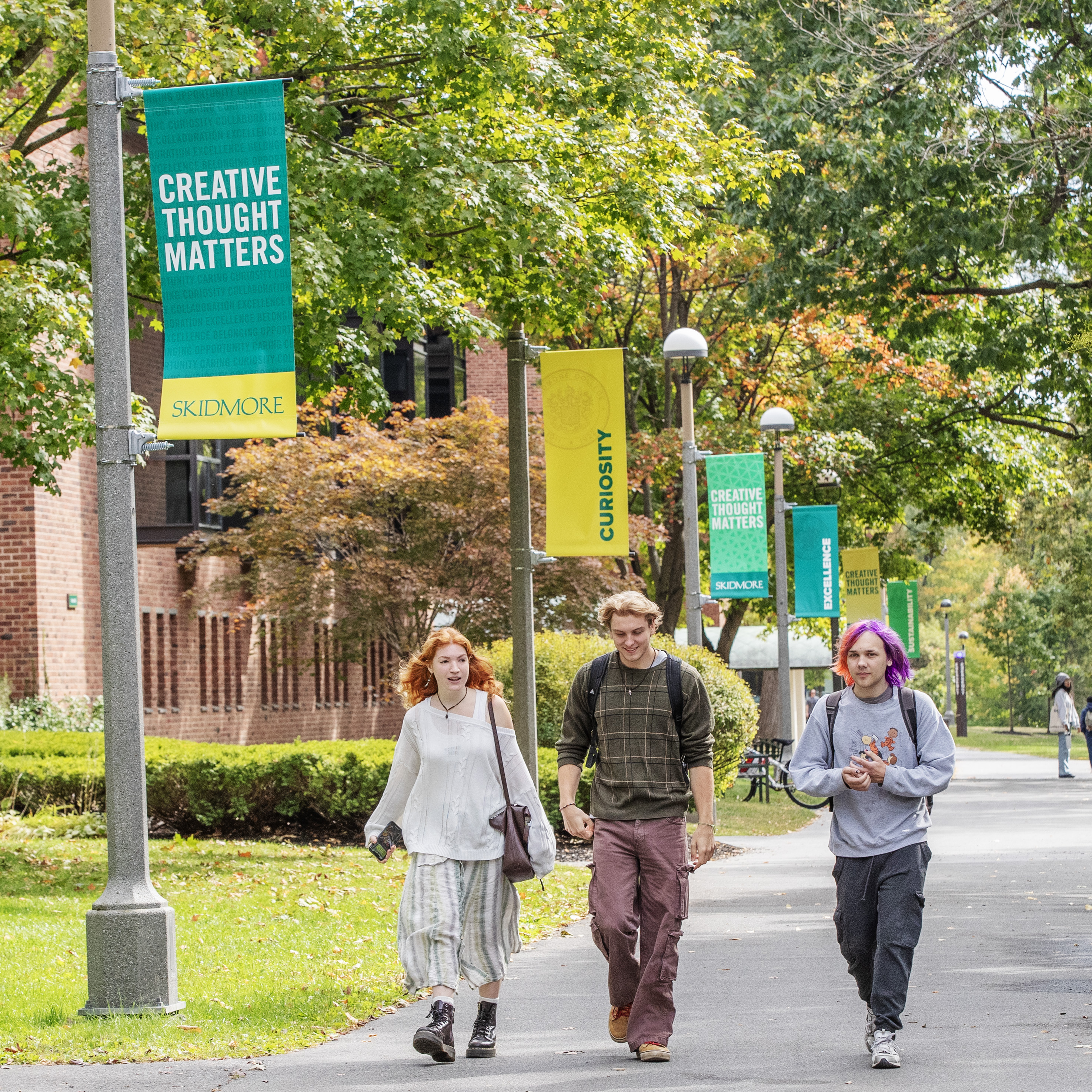 Students+walk+on+Skidmore%27s+campus+near+flags+reading+%22Creative+Thought+Matters%22+and+%22curiosity.%22+