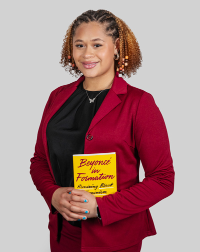 Alanna Herbert ’29 poses with a book about Beyoncé.