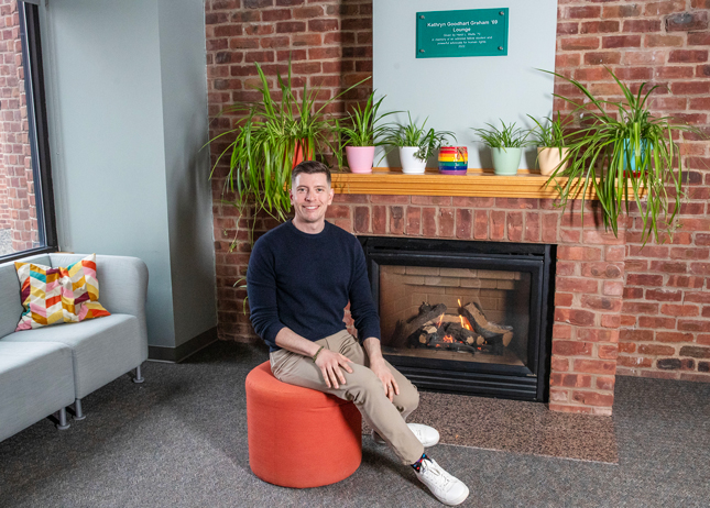 Fred Braunstein ’08 sits in front of the fireplace in Skidmore's Wyckoff Center