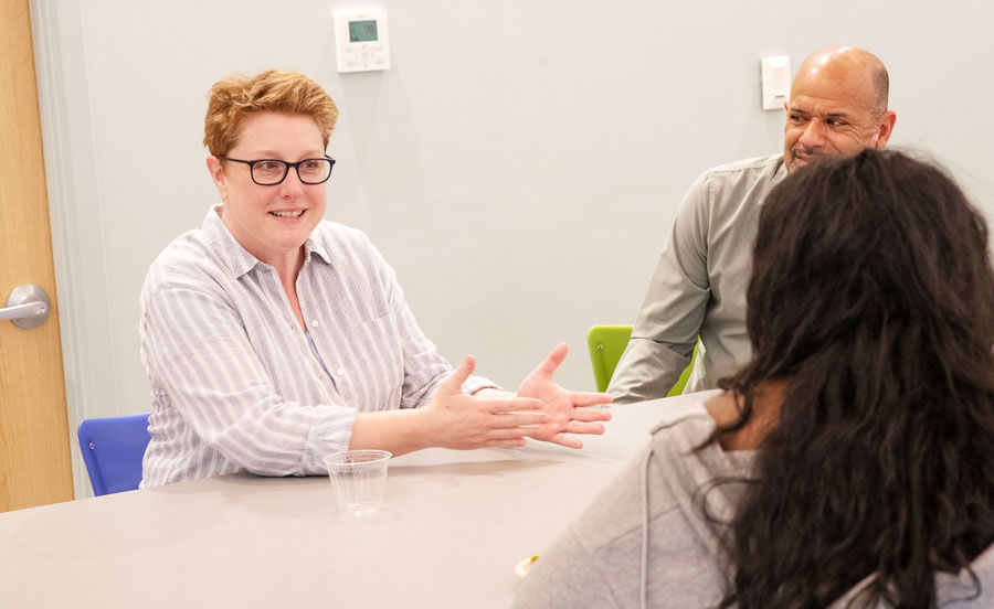 Suzi Pond offers advice to a student while sitting at a table in Skidmore's Wyckoff Center