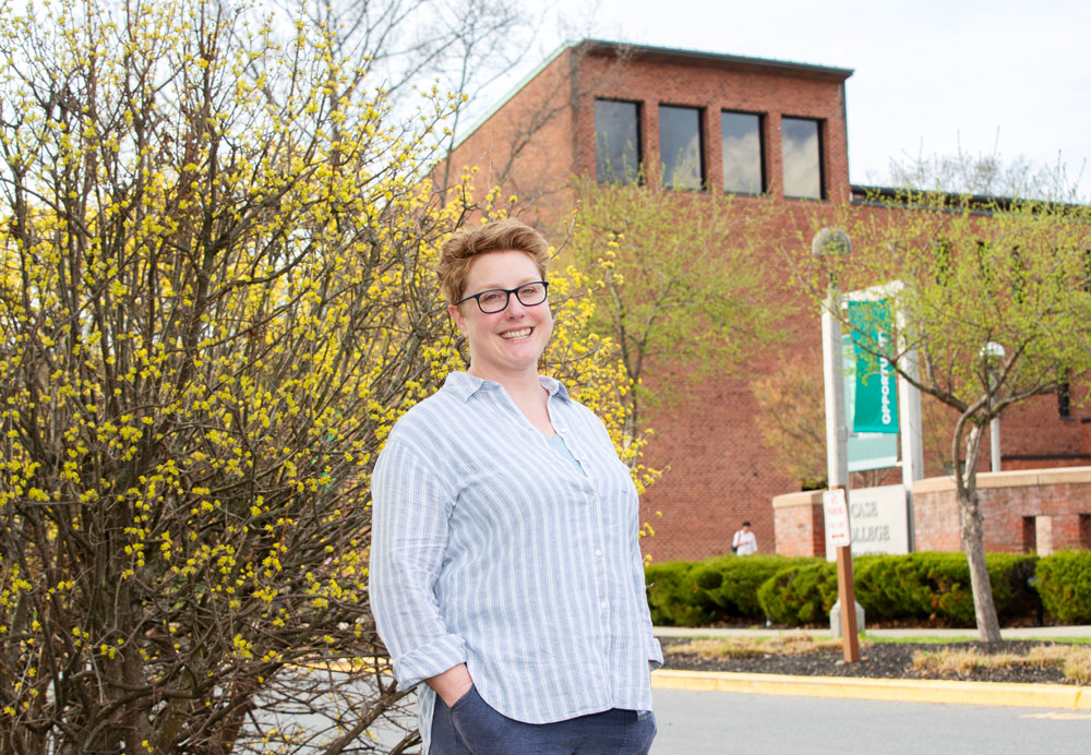 Suzi Pond stands in front of a blossoming tree near Case Center's Porter Plaza