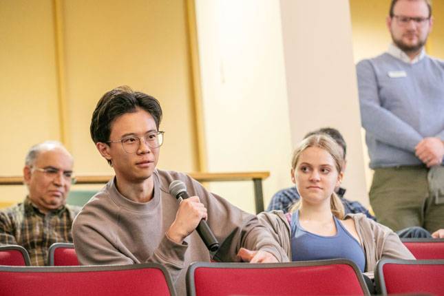 A student speaks into a microphone during a presenting.