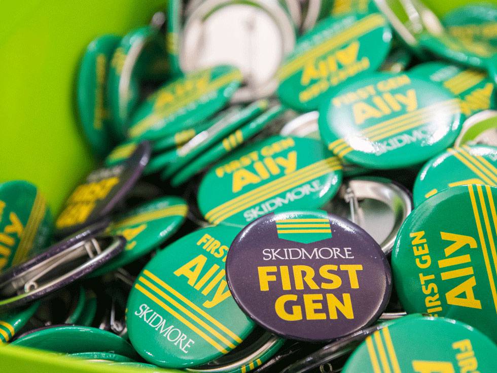 Various green and black Skidmore-branded pins supporting first-generation students.