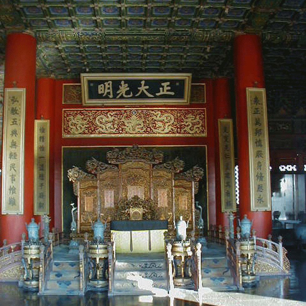 Interior of ornate temple in China, adorn with gold details and red columns.
