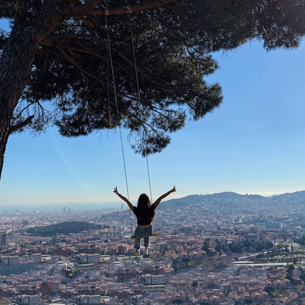 A student swings out overlooking a Spanish village