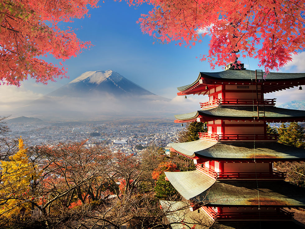 Japanese style tower with snow capped mountain in the background